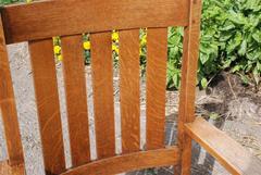 View of the quarter sawn oak grain in the back and legs and the double pinning of the mortise and tenon construction where the crest rail joins the top of the leg.